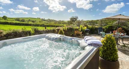 Eine große Whirlpool in einem schönen Garten mit vielen Jets, von einem unserer Ferienhäuser mit Whirlpools in Großbritannien.