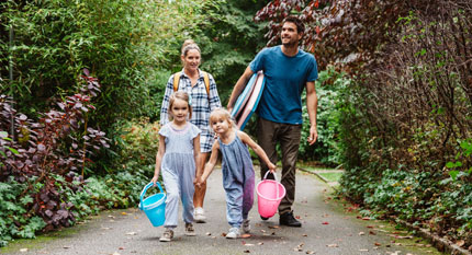 A family of four on holiday, walking from their holiday cottage to the beach